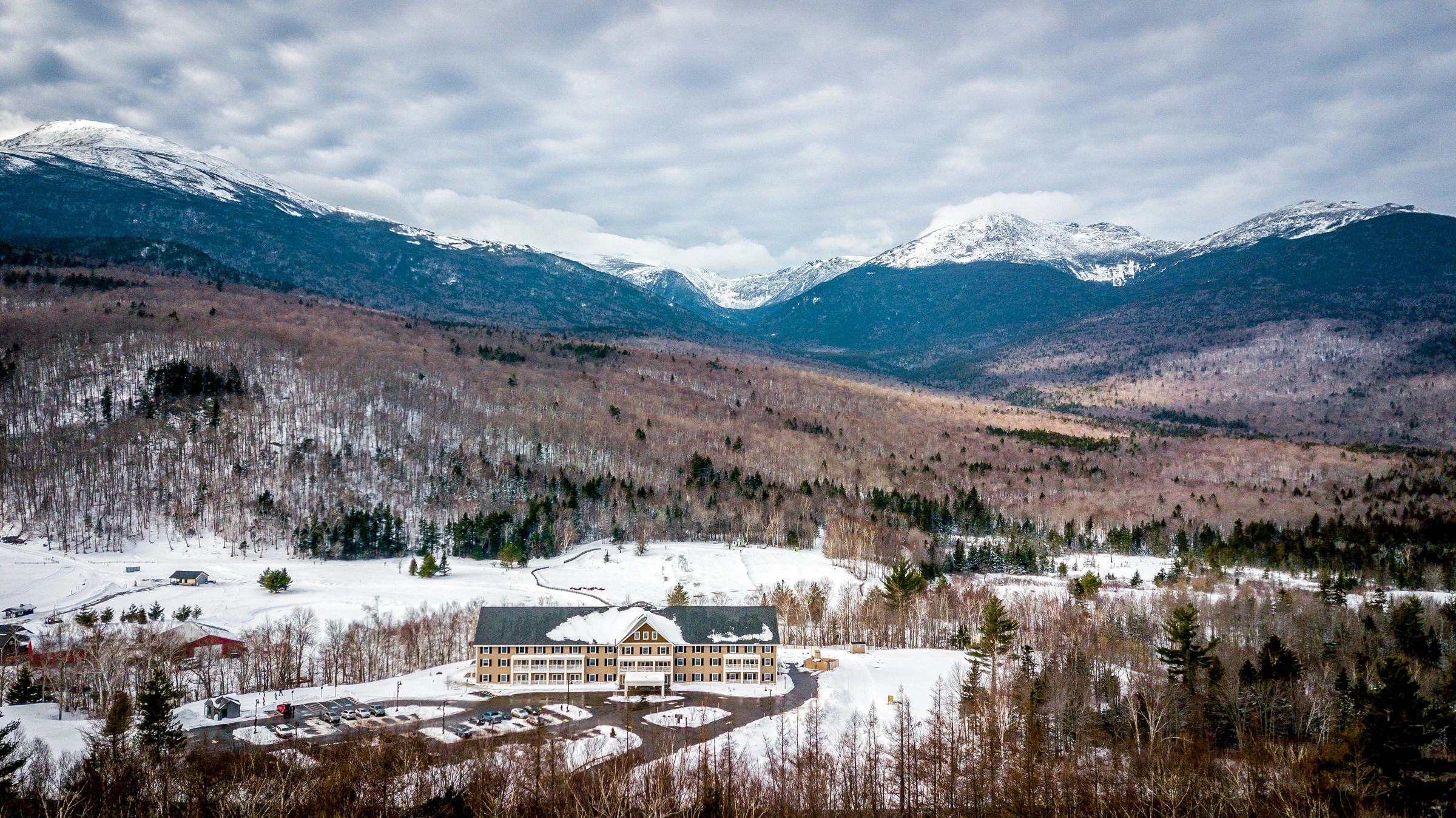 Aerial view of The Glen House during the winter with a view of the mountains in the background
